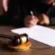 Judge writing with gavel present during Tax Court of Canada - procedure and process guide, explained by KR Law Firm - Tax Law Firm in Toronto