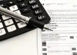 Pen, calculator, and CRA form for understanding tax litigation in Toronto explained by KR Law Firm - A Canadian Tax Law Firm in Toronto